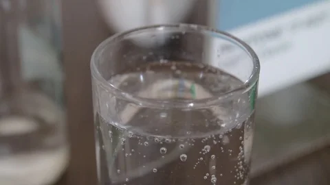 Many Bubbles burst on the surface of a glass of water Stock-Footage 73056539