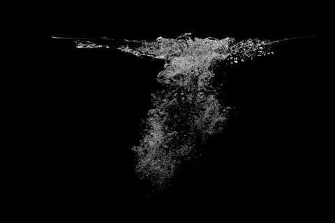 Many bubbles under the water surface, completely black background. Stock Photos