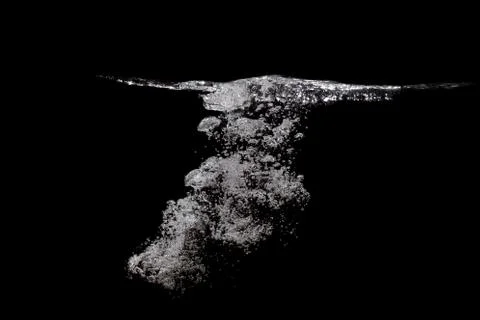 Many bubbles under the water surface, completely black background. Stock Photos