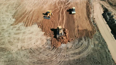 A many bulldozer levels a plot of land for development. Drone top down footage. Stock Footage 224776898