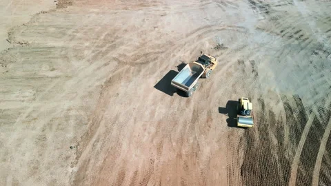 A many bulldozer levels a plot of land for construction development. Drone top Stock Footage 226210428