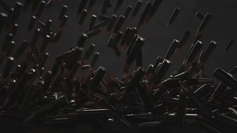 Many bullets fall on the table. In the background a dark wall Stock Footage 99878150