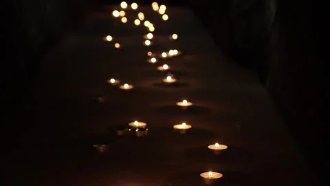 Many burning candles in the dark. A path of lit small candles in a black room. Stock Footage 286826336