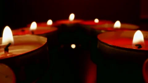 Many burning candles in darkness, moving macro shot, closeup view of flame Vídeo Stock 236535010
