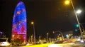 Many cars rushing by illuminated Torre Agbar, hectic night city life, time-lapse 4k or 4k+ Resolution