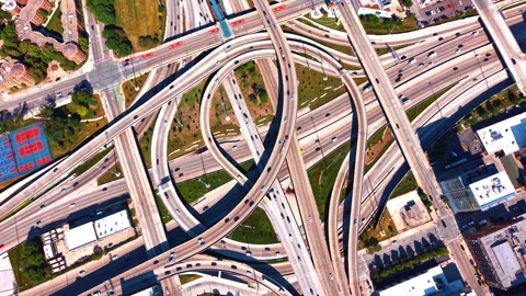 Many cars on the swirling, circular pattern of sweeping concrete flyover ramps Stock Footage 338308481