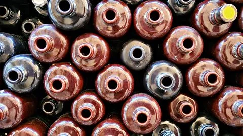 Many ceramic empty bottles for alcoholic drink balsam are stacked in wooden.. Foto stock