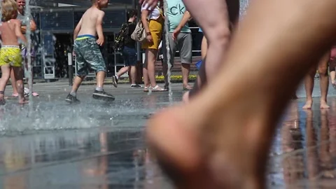 Many children run under running water on a hot summer sunny day. Belarus Mogilev Stock Footage 157068617