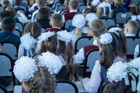 Many children sit dressed in the assembly hall at a concert dedicated to the Day Stock Photos