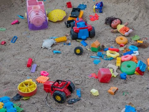 Many children's multi-colored plastic toys are scattered on the ground. Stock-Fotos