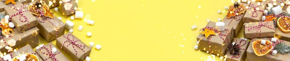 Many Christmas gift boxes on Illuminating yellow background. Wrapped craft paper Stock Photos