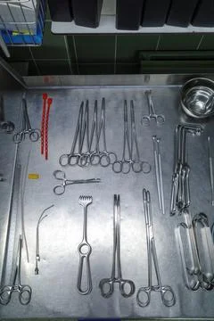 Many cleaned instruments for performing vascular surgery lie on a metal table Stock Photos