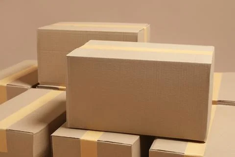Many closed cardboard boxes on light brown background Foto stock