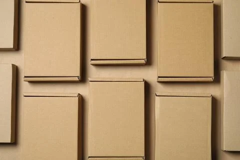 Many closed cardboard boxes on light brown background, flat lay Stockfoto's
