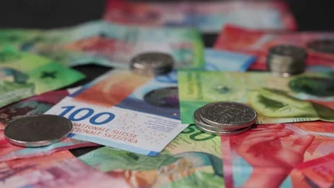 Many coins distributed on Swiss banknotes. The Swiss economy is doing well. Vídeo Stock 234544230