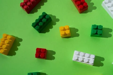 Many colored details of children's constructor, pattern, isolated on green ba Stock Photos