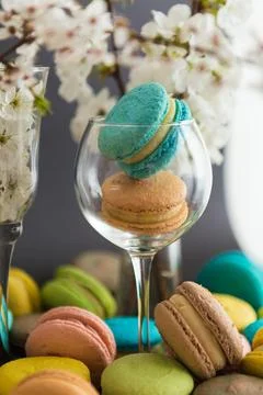 Many colored macaroons on a black background with white apple blossom Foto stock