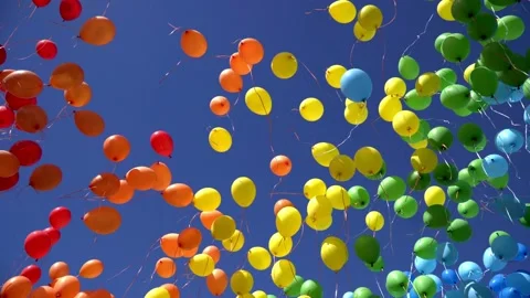 Many colorful balloons rise and fly across the sky. Red, blue,orange, yellow and Stock Footage