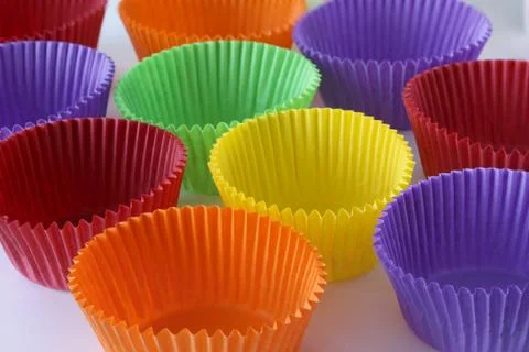Many colorful empty paper forms capsules for muffins and cupcakes on white Stock Photos