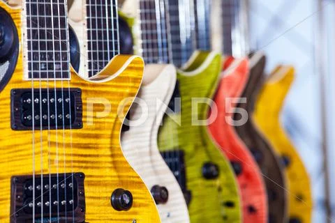 Many colorful guitars in musical shop Stock Photos