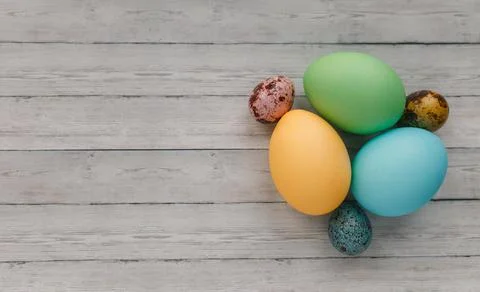 Many colorful painted Easter eggs on light wooden background, top view. Space 写真素材