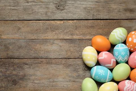 Many colorful painted Easter eggs on wooden background, top view. Space for t 스톡 사진