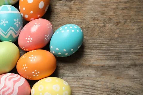 Many colorful painted Easter eggs on wooden background, top view. Space for t Stock Photos