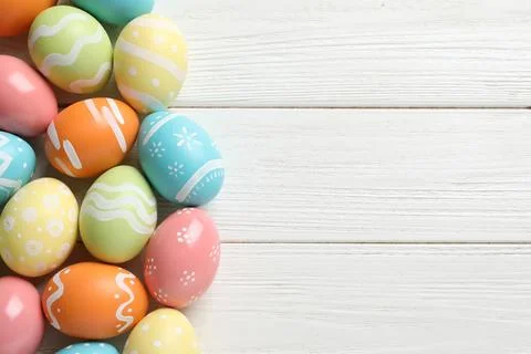 Many colorful painted Easter eggs on wooden background, top view. Space for t Stock Photos