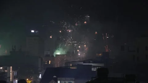 Many Colorful Tet Fireworks Exploding over Night City Skyline Stock Footage 339638291
