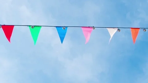 Many colorful triangular flags blowing on the wind on blue sky Stock Footage 82197870
