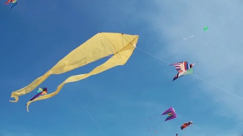 Many colourful kites hovering in blue sky and sunny day. Video stock 76265309