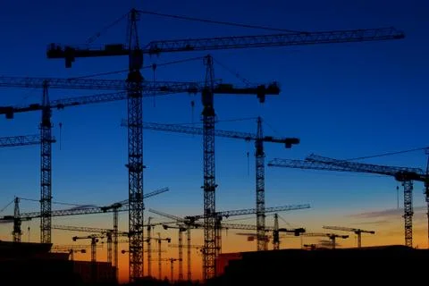 Many construction cranes on sunset sky , crane silhouette skyline 写真素材