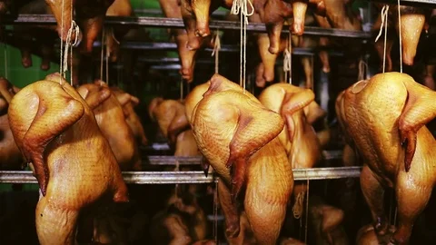 Many cooked chicken grills hang on metal skewers in the kitchen. Stock Footage 83982591