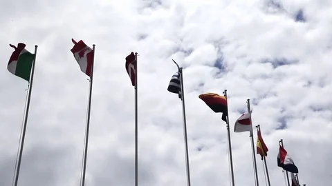 Many country flag wind on flag poles Canadian, Britain, germany, japanese flags Stock Footage 128928982