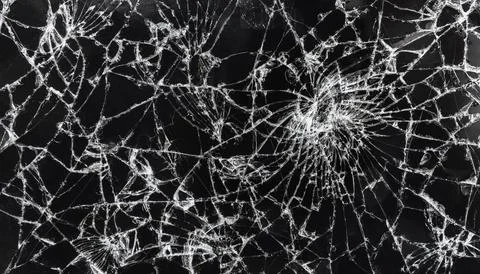 Many cracks on the smartphone screen, close-up for background Stock Photos