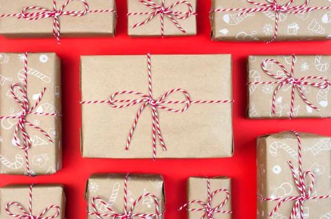 Many craft gift boxes on red background. Christmas packaging wrapped vintage Stock Photos