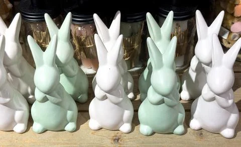 Many decorative ceramic Easter bunnies arranged on a holiday table Foto stock