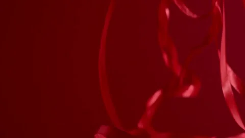 Many deep red satin ribbons falling down on a red background. FHD still shot Stock Footage 145053872