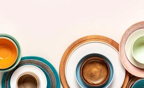 Many different ceramic plates and bowls on a light background Stock Photos