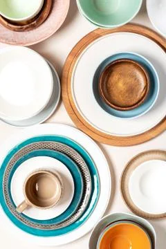 Many different ceramic plates and bowls on a light background, top view. Foto stock