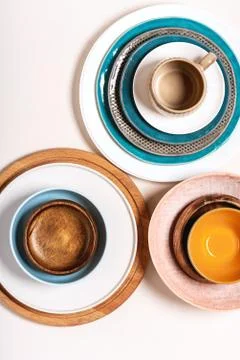 Many different ceramic plates and bowls on a light background Foto stock