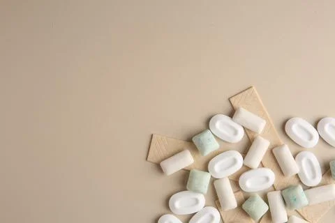 Many different chewing gums on beige background, flat lay. Space for text Stock Photos