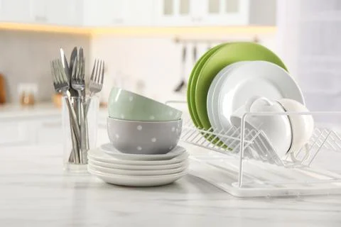Many different clean dishware, cups and cutlery on white marble table in ki.. Stock Photos