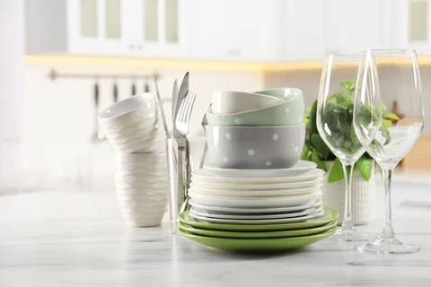 Many different clean dishware, glasses, cups and cutlery on white marble ta.. Stock Photos