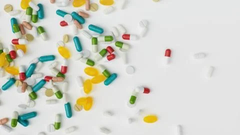 Many different colored tablets, capsules isolate on white background. Health Stock Illustration