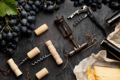 Many different corkscrews with open wine corks on dark concrete background in Stock Photos
