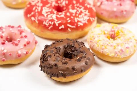 Many different donuts on a white background top view, pink, white and choco.. 스톡 사진