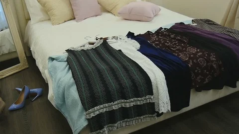Many different dresses on the bed Stock Footage 75939545