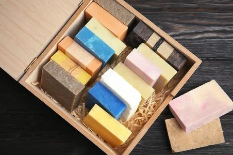 Many different handmade soap bars in wooden box on table, top view Foto stock