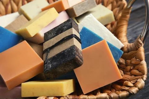 Many different handmade soap bars in wicker basket, closeup Foto stock